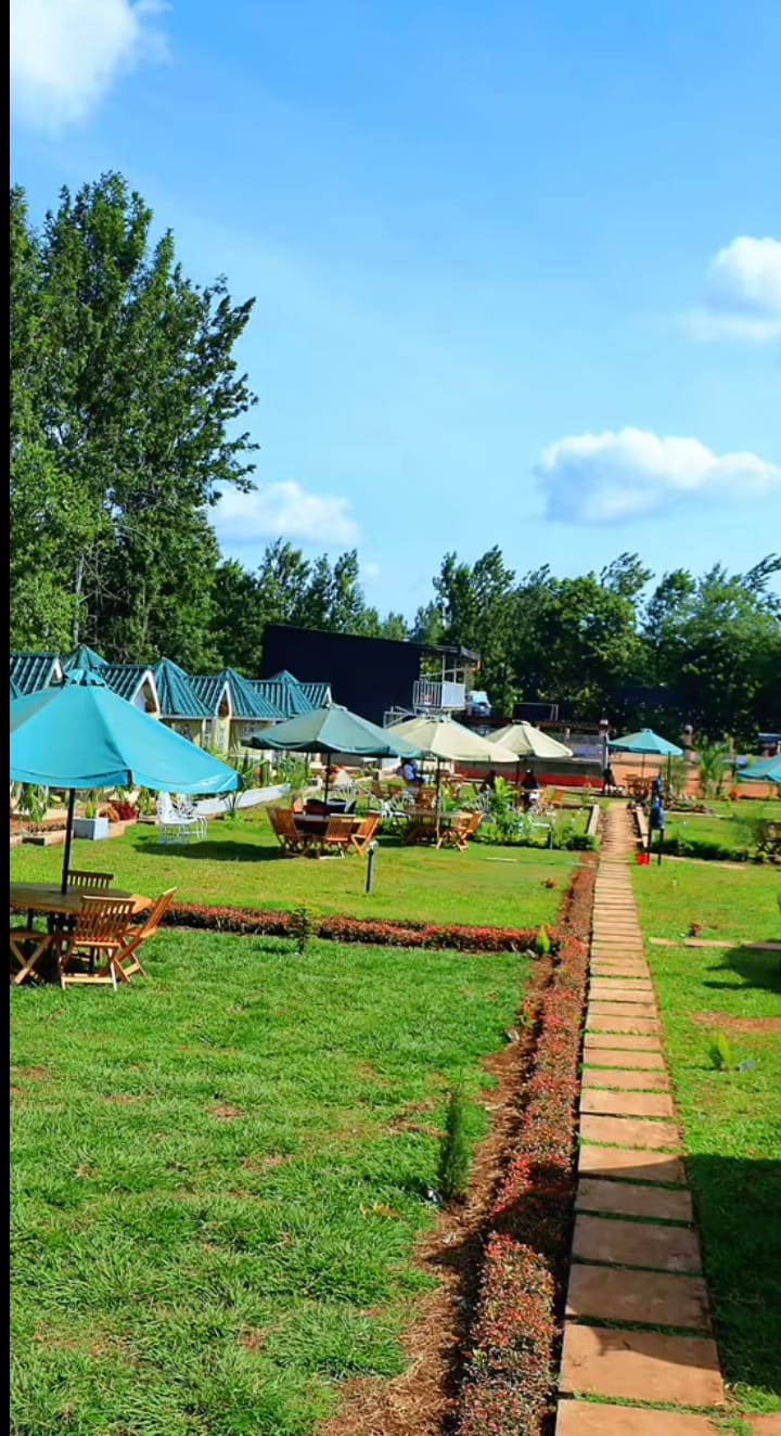 Ayana Gardens lawn with umbrellas and wooden tables